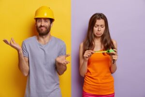 Man shrugging in hard hat (pecuniary loss) next to woman frowning, holding a measuring tape (non-pecuniary loss).