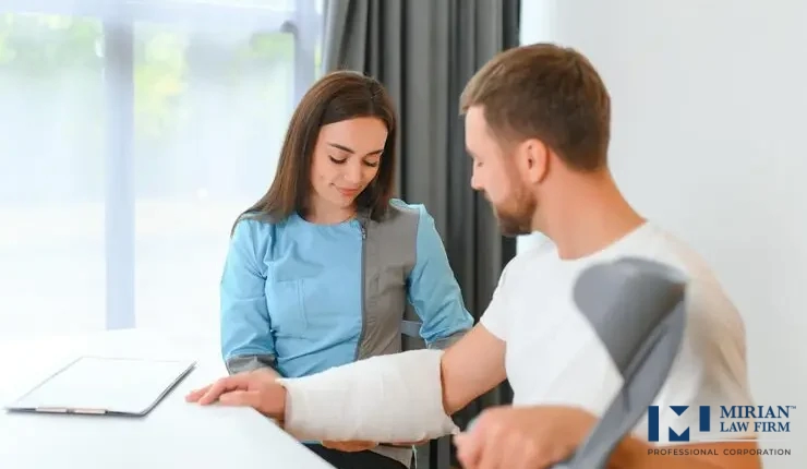 An injured man with a cast and crutches sits with a healthcare worker or legal assistant.